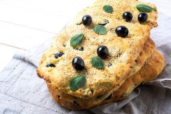 Stack of traditional Italian bread focaccia with olive, garlic and herbs. Homemade traditional Italian bread focaccia.