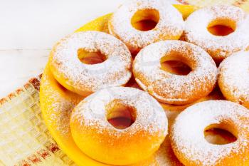 Sweet donuts served on yellow plate. Homemade dessert pastry doughnuts.   Hanukkah sweet donuts. 