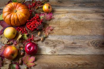 Thanksgiving  greeting background with pumpkins, apples and fall leaves. Thanksgiving background with seasonal vegetables and fruits.  