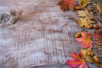 Thanksgiving  greeting with acorn and fall leaves on wooden background. Thanksgiving background with fall leaves. Copy space