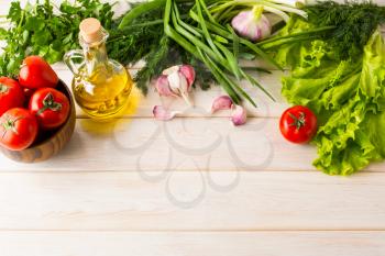 Tomato, olive oil and garlic on white wooden background. Healthy eating concept with fresh vegetables. Vegetarian  vegan food background. Copy space.