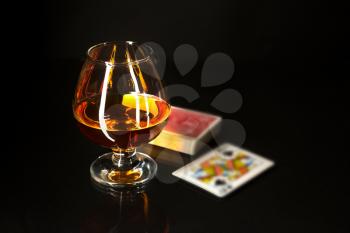 Whiskey glass and playing cards. Cognac glass. Brandy glassful. Cognac france. Playing cards and scotch drink. 