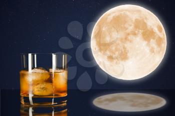 Whiskey glass on midnight sky with full moon background. Cognac glass. Brandy glassful. Cognac france. Full moon and scotch drink. Full moon on the night sky. Full mystic Moon.