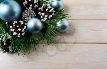 Christmas background with blue ornaments and snowy pinecone. Christmas party decoration with shiny balls. Copy space.