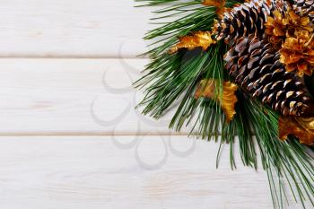 Christmas holiday background with golden decorated fir and pine cones. Christmas decoration with golden decor. Christmas greeting background. Copy space.