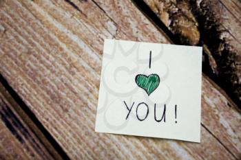 I Love You emotional handwritten message written on the white paper with retro wooden bark background. Emotional handwritten messages on the paper. Emotional concept message.