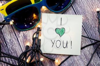 I love you note Glasses having yellow and blue colors Lights present in this picture. Love for a particular person any is expressed in the above note