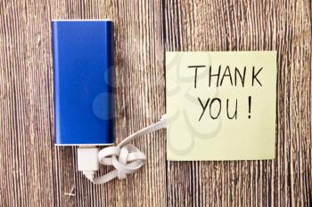 Thank You note, and blue colored energy bank and USB cable is attached. In above picture gratitude, appreciation, or acknowledgment is benig expressed.