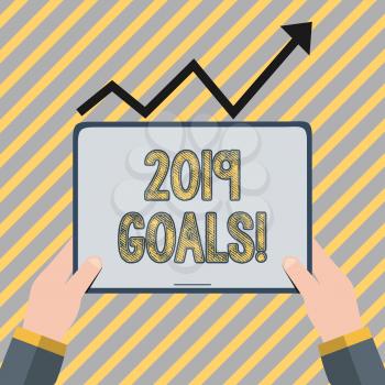 Writing note showing 2019 Goals. Business concept for something you hope to achieve or get in near or far future Hand Holding Tablet under the Progressive Arrow Going Upward