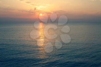 Sunset Sea over the Horizont. Beautiful Ocean Sunshine Landscape, Mediterranean Twilight with yellow colors, Warm marine dusk Sun Reflecting sunlight over the water
