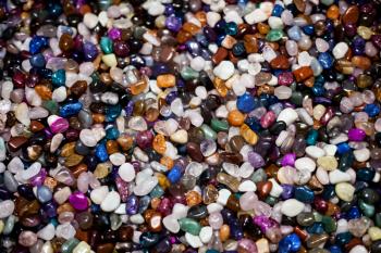 Colorful background with small stones. Abstract background with colored rocks. Closeup image of decorative stones. Shiny precious small stones background.