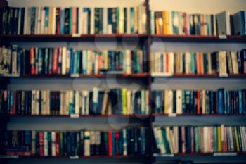 Shelves with books in a blurred background. Abstract colorful blurred background with books. Learning concept with blurred library books on the shelves.