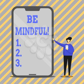 Writing note showing Be Mindful. Business concept for Asking demonstrating become conscious or aware of something Man Presenting Huge Smartphone while Holding Another Mobile