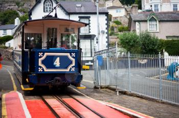 Famous vintage Great Orme tram in  LLandudno, Wales. Great Orme Mountain in LLandudno, Wales. Traditional tramway makes its way across the mountain, public transport on metallic rails, electrical streetcar in rural scene