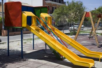We can Slide and Swing red and yellow colour for two to play. It is in a childrens park located in  quiet neighbourhood with cars and houses outside the limits of the park.