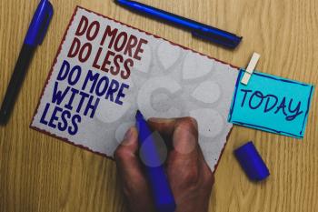 Conceptual hand writing showing Do More Do Less Do More With Less. Business photo text dont work hard work smart be unique Man holding marker paper clothespin express ideas wooden table