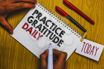 Writing note showing Practice Gratitude Daily. Business photo showcasing be grateful to those who helped encouarged you Man holding marker notebook clothepin reminder wooden table cup coffee