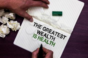 Text sign showing The Greatest Wealth Is Health. Conceptual photo being in good health is the prize Take care Man holding marker notebook page crumpled papers several tries mistakes
