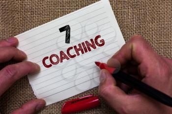 Writing note showing 7 Coaching. Business photo showcasing Refers to a number of figures regarding business to be succesful Man's hand hold white paper with symbolic letter jute sack background