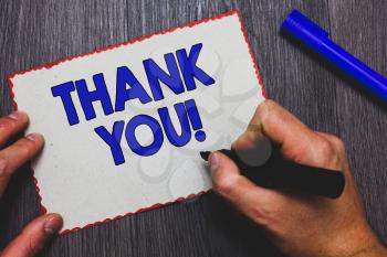 Writing note showing Thank You. Business photo showcasing replaying on something good or greetings with pleased way Man holding marker paper red borders express ideas Wooden background