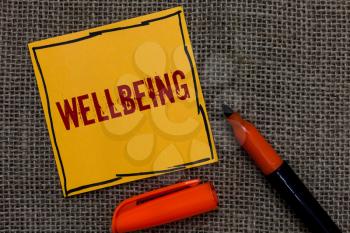Conceptual hand writing showing Wellbeing. Business photo showcasing A good or satisfactory condition of existence including health Orange paper Marker Communicate ideas Jute background