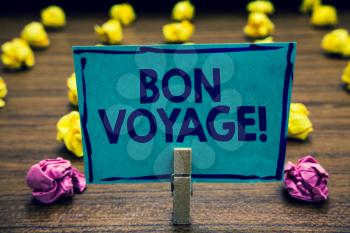 Text sign showing Bon Voyage. Conceptual photo used express good wishes to someone about set off on journey Clothespin holding blue paper note crumpled papers several tries mistakes
