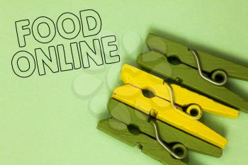 Text sign showing Food Online. Conceptual photo asking for something to eat using phone app or website Three green yellow vintage clothespins clear background Holding things