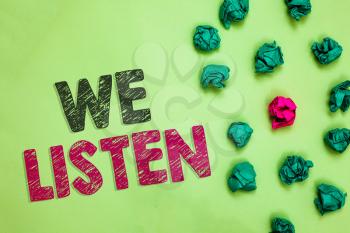 Text sign showing We Listen. Conceptual photo Group of people that is willing to hear anything you want to say Crumpled wrinkled papers one different pink unique special green background