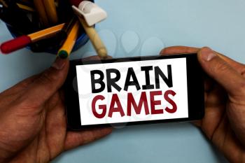 Conceptual hand writing showing Brain Games. Business photo showcasing psychological tactic to manipulate or intimidate with opponent Man holding cell phone looking messages apps cup markers