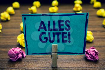 Text sign showing Alles Gute. Conceptual photo german translation all the best for birthday or any occasion Clothespin holding blue paper note crumpled papers several tries mistakes