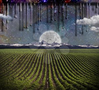 Surrealism. Field with green rows. Giant moon rises over the mountains. Another dimension flows down.
