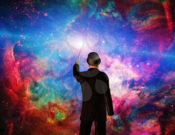 Man in suit with magic wand creates universe.