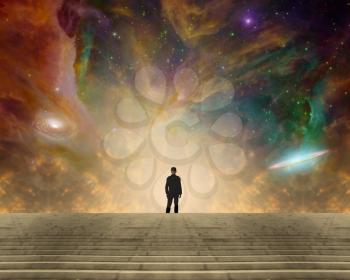 Sci-fi composition. Stargazer. Man in classic suit and bowler hat stands before vivid space with colorful nebulae and galaxies