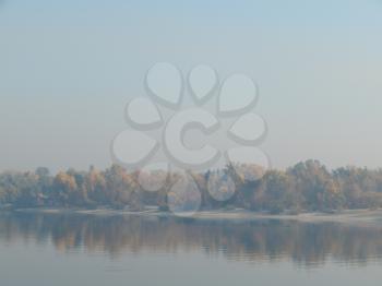 Panorama of the autumn city in a haze of fog over the river