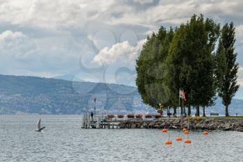 Man standing on a jetty on the shore of Lake Geneva in Switzerland