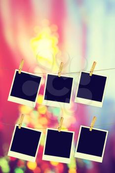 Old photo film blanks hanging on a rope held by clothespins on bokeh lights background.