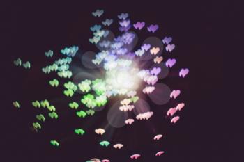 Defocused background with colorful bokeh in a shape of a heart.