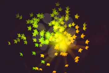 Defocused background with colorful bokeh in a shape of a star.
