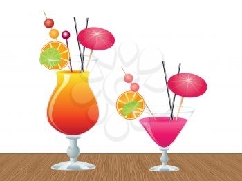 Two glasses of tropic cocktail on wooden table background.