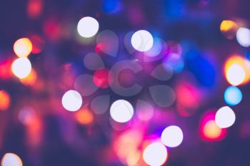 Decorated Christmas tree and colorful garland lights, defocused background, bokeh.