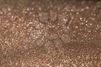 Decorative brown glitter texture macro, defocused background, bokeh.