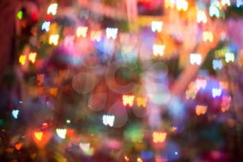 Festive background with butterfly shaped bokeh from Christmas tree lights glowing. 