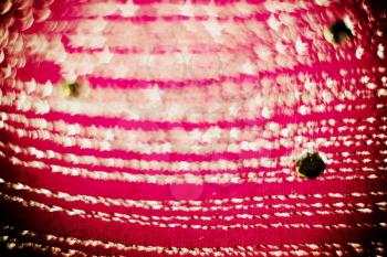 Textile of pink color decorated with strasses, bokeh effect, textured with paper.