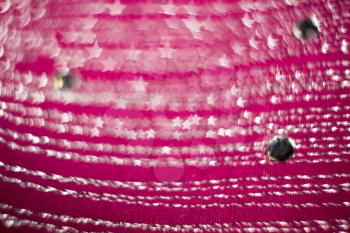 Textile of pink color decorated with strasses, bokeh effect.