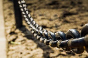 Close up of black chains barrier stand in the city park.