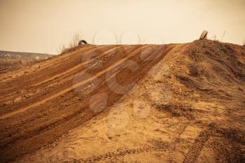 Trail of treads on a sandy quarry retro background.