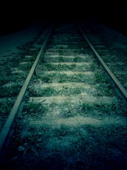 Old forgotten railroad in the dark, vintage background.