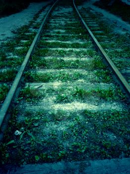 Old fogotten railroad in the dark, vintage background.