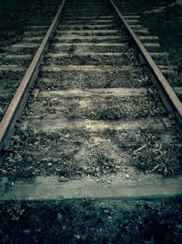 Old fogotten railroad in the dark, vintage background.