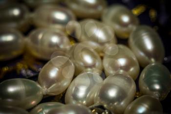 Natural white freshwater pearl necklace close up filtered background.